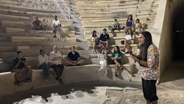 A speaker at the ancient theatre of Patara during ZuKaş 2025